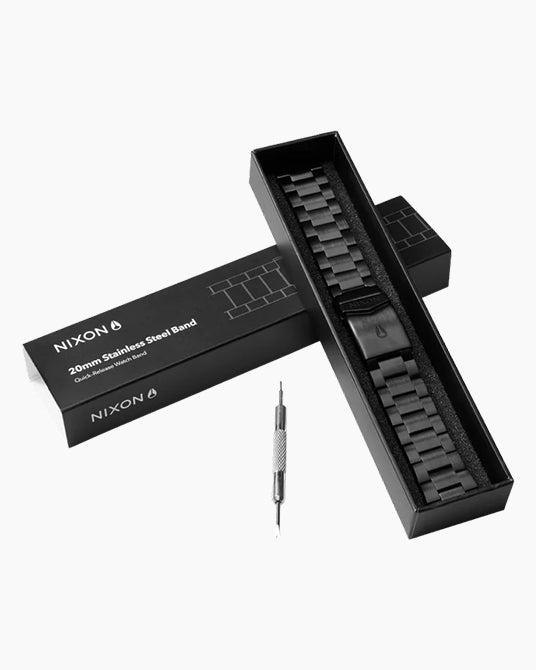Nixon watch band kit with black band, tool, and packaging on a white background