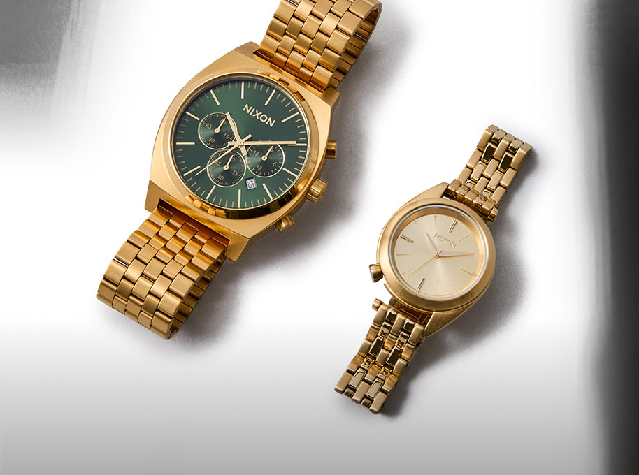Two gold watches on a light gray background